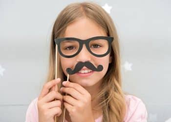 Child with a fake moustache and glasses to get around age verification