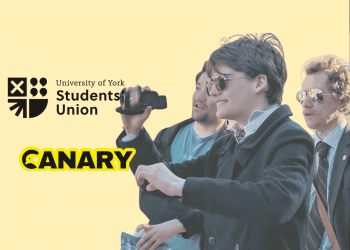 A picture of a Restore Britain Society fan holding a camera. On the left are both the University of York Student Union Logo and the Canary UK logo