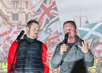 Tommy Robinson in front of various flags