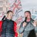 Tommy Robinson in front of various flags