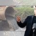 Andy Burnham in front of a sewage pipe