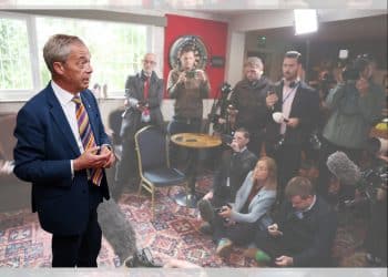 Reform leader Nigel Farage in a room full of journalists