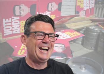 Andy Burnham in front of campaign banners
