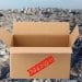 Composite image showing a shipping box with an Approved stamp on it over an aerial view of destruction in Gaza. UK export licence military equipment to Israel
