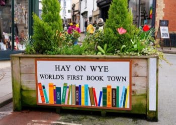 Sign on a planter says Hay On Wye World's First Book Town Hay Festival Airbnb