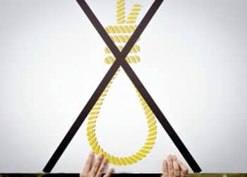 A protester against Israel's death penalty law holds a placard showing a noose crossed out