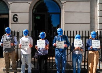 Protesters wearing blue masks outside Rio Tinto office.