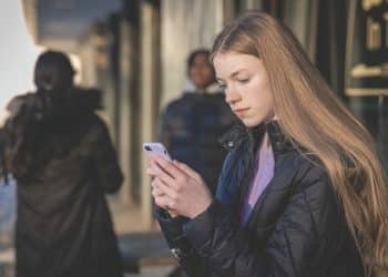 A girl looks at a mobile phone Online misogyny Barnardo's
