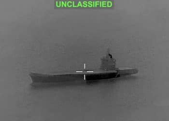 A CCTV-looking grey image of a vessel in the middle of the Strait of Hormuz with a white target cross in the middle of it and the word 'unclassified' in green above. It's a screen grab of a video before smoke plumes from the vessel.
