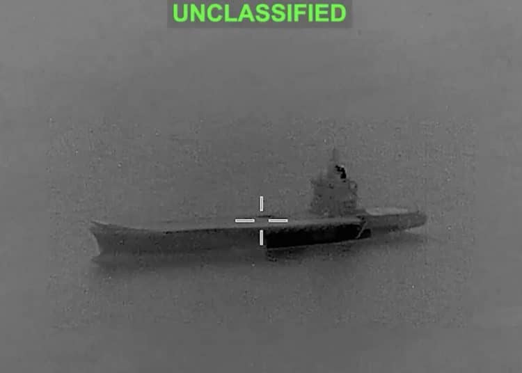 A CCTV-looking grey image of a vessel in the middle of the Strait of Hormuz with a white target cross in the middle of it and the word 'unclassified' in green above. It's a screen grab of a video before smoke plumes from the vessel.