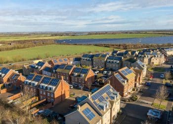 Illustrative image of houses with solar panels and a solar farm in the background Fairer pricing through renewable energy