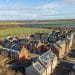 Illustrative image of houses with solar panels and a solar farm in the background Fairer pricing through renewable energy