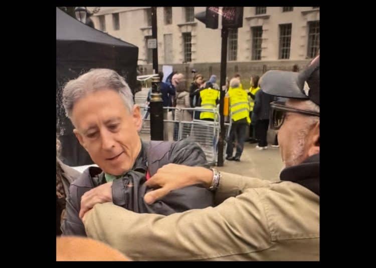 a man grabs Peter Tatchell at the Rally Against Antisemitism