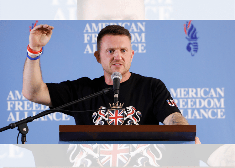 Tommy Robinson holding his hand up
