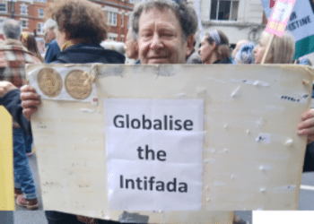 Tony Greenstein holding the 'Globalise the Intifada' slogan poster at the Nakba Day march in London on 16 May 2026