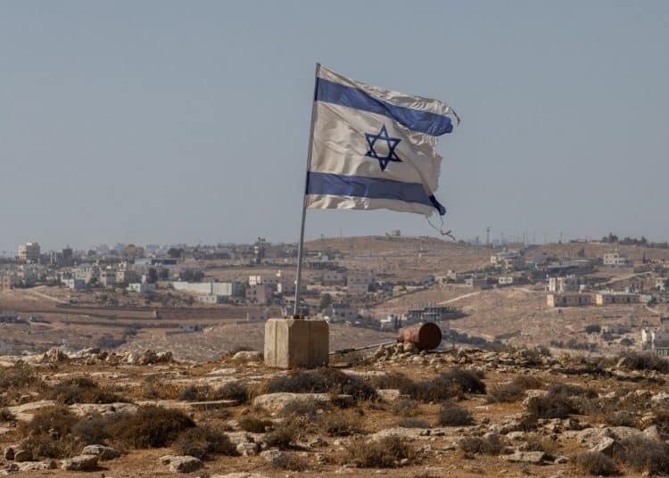 A tattered Israel flag flies near a West Bank settlement