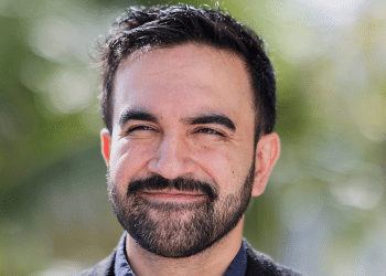 A sunny head shot of Zohran Mamdani