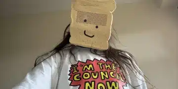 Zöe Bread wearing a sliced white bread mask and a comic style slogan tshirt saying, 'I'm the council now'.