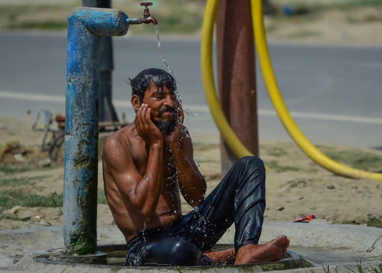 ALLAHABAD, INDIA - MAY 21: A man cools himself under a public water tap during a heatwave on May 21, 2026 in Allahabad, India. (Photo by Ritesh Shukla/Getty Images)