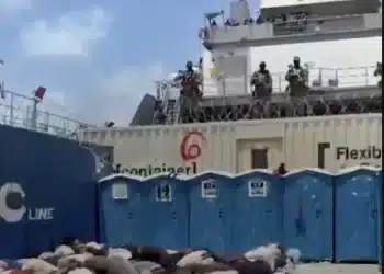 Bodies, likely of the Global Sumud Flotilla volunteers, crouch over in rows on what appears to be the deck of a ship