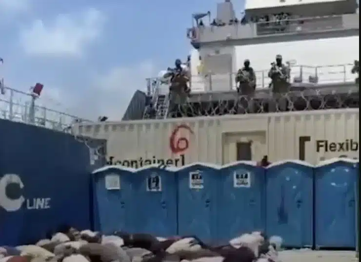 Bodies, likely of the Global Sumud Flotilla volunteers, crouch over in rows on what appears to be the deck of a ship