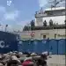 Bodies, likely of the Global Sumud Flotilla volunteers, crouch over in rows on what appears to be the deck of a ship