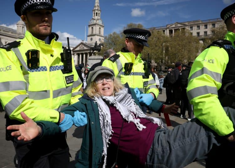 LONDON, ENGLAND - APRIL 11:  Police make arrests as demonstrators participate in 'Everyone Day', a mass action against the Government's proscription of Palestine Action, at Trafalgar Square on April 11, 2026 in London, England. Defend Our Juries is organising the 'Everyone Day' mass action to protest the UK Government's proscription of Palestine Action. Participants are engaging in civil disobedience by publicly opposing the ban, despite risks of arrest under the Terrorism Act. (Photo by Dan Kitwood/Getty Images)