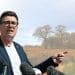 Andy Burnham in front of an image of a field