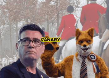 An image of the hunt and hounds in the background, wearing the traditional red coats. In the foreground on the left is Robert Pownall dressed as a fox. He is wearing a red, blue and white rosette and is waving at the camera. To the left of him is Andy Burnham looking perplexed. In the middle is the Canary UK logo