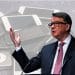Peter Mandelson in front of pictures of mobile devices