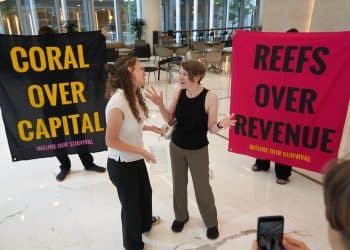 Boycott Bloody Insurance activists in the lobby of the Walkie Talkie. Banners say: Coral Over Capital and Reefs Over Revenue