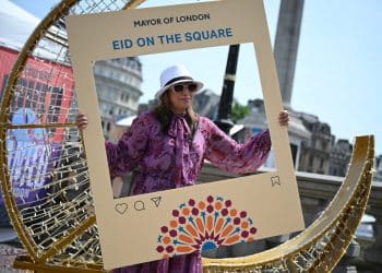 A festival goer poses in a photo frame at Eid on the Square 2026