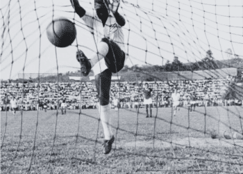 Brazilian footballer Pele in the net after scoring for Santos