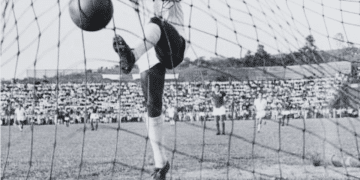 Brazilian footballer Pele in the net after scoring for Santos