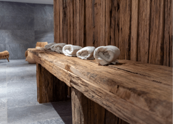 Folded Beige Towels Ready for Use in Spa on Rustic Wooden Table