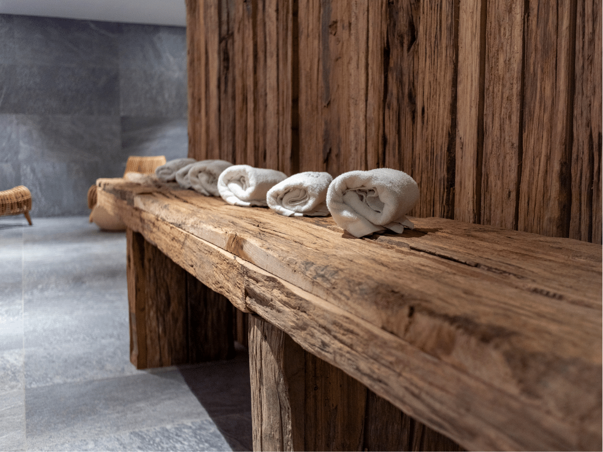 Folded Beige Towels Ready for Use in Spa on Rustic Wooden Table