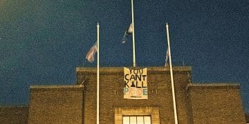 Havering Town Hall with Pride and Trans flags flying from flagpoles and a banner saying YOU CAN’T KILL PRIDE - XOXO TKDB