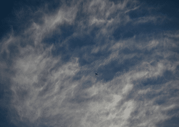 An Israeli air-force single isolated drone in the distance with partly cloudy background. This is not a photo of Israel's AI killer drones in the story.