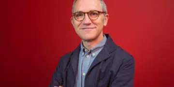 A professional portrait of James Purnell, with his arms folded against a red background. Andy Burnham has appointed him as chief of staff.