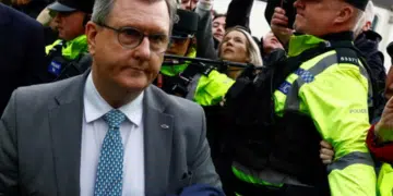 Jeffrey Donaldson, former leader of the Democratic Unionist party, arriving in court for the first time over historical sex offence charges, surrounded by police officers