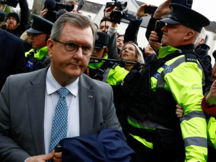 Jeffrey Donaldson, former leader of the Democratic Unionist party, arriving in court for the first time over historical sex offence charges, surrounded by police officers