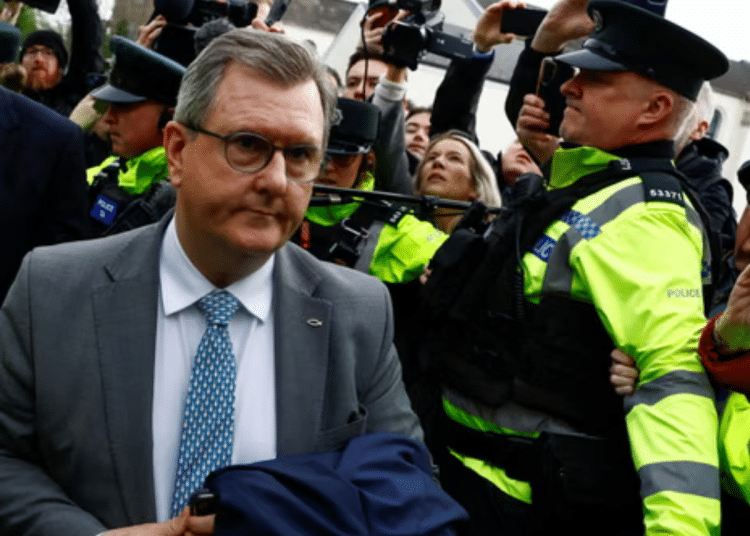 Jeffrey Donaldson, former leader of the Democratic Unionist party, arriving in court for the first time over historical sex offence charges, surrounded by police officers