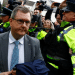 Jeffrey Donaldson, former leader of the Democratic Unionist party, arriving in court for the first time over historical sex offence charges, surrounded by police officers