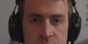 A screenshot of Irish Michael McCarthy speaking on this video, wearing headphones