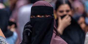 A Kashmiri Muslim woman speaks on her mobile phone in a market, ahead of Eid al-Adha, one of the most important festivals in Islam on May 25, 2026 in Srinagar, India.