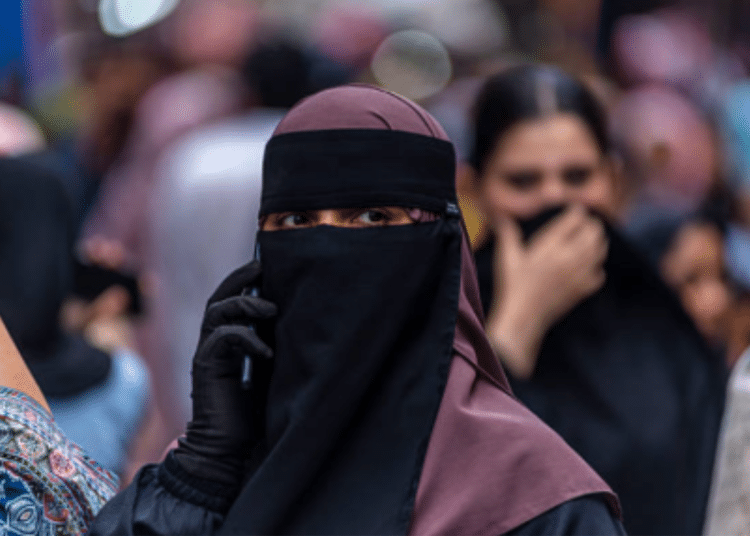 A Kashmiri Muslim woman speaks on her mobile phone in a market, ahead of Eid al-Adha, one of the most important festivals in Islam on May 25, 2026 in Srinagar, India.