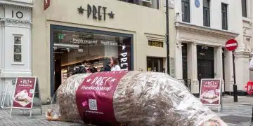 A giant model chicken, labelled as a FrankenWrap, lies on the pavement outside a branch of Pret A Manger