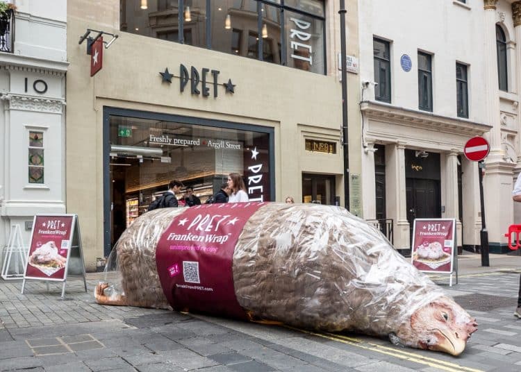 A giant model chicken, labelled as a FrankenWrap, lies on the pavement outside a branch of Pret A Manger