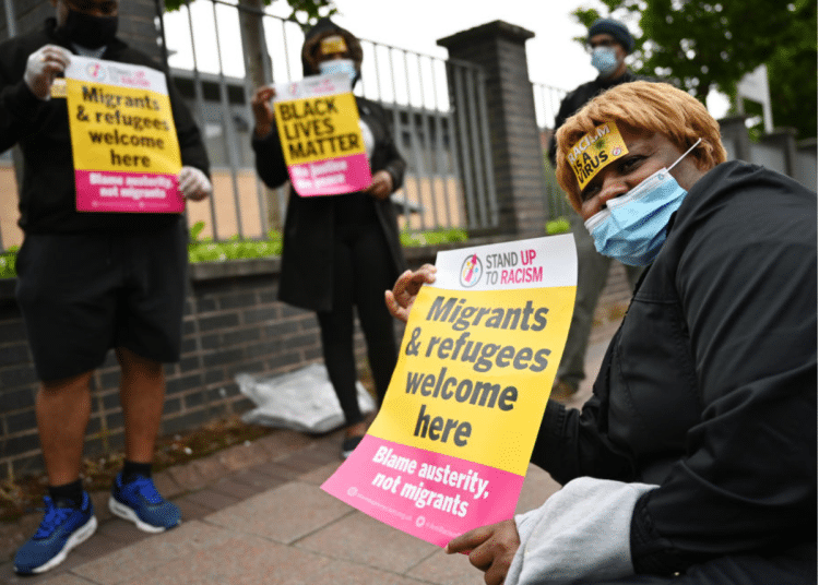 Protesters join a 'Refugees Lives Matter' protest on July 1, 2020 in Glasgow, Scotland. They are holding posters saying: 'Migrants and Refugees welcome here - Blame austerity not migrants'. The crisis in social care will worsen if sponsored workers are further forced to leave