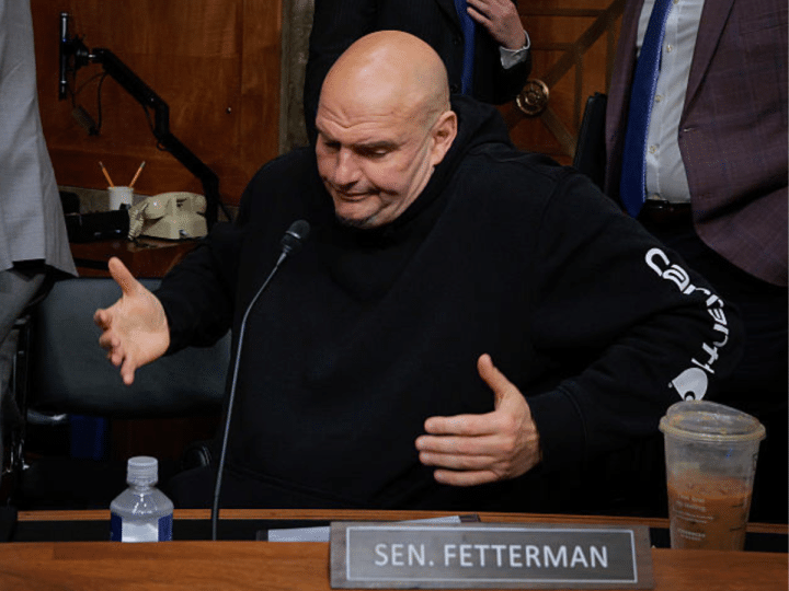 Senate Homeland Security and Governmental Affairs Committee member Senator John Fetterman shrugs after voting for Senator Markwayne Mullin to be Secretary of the Department of Homeland Security at the Dirksen Senate Office Building on Capitol Hill on 19 March 2026 in Washington, DC in the US